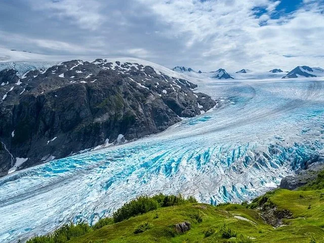 A large, crevassed glacier flowing down a mountain valley.